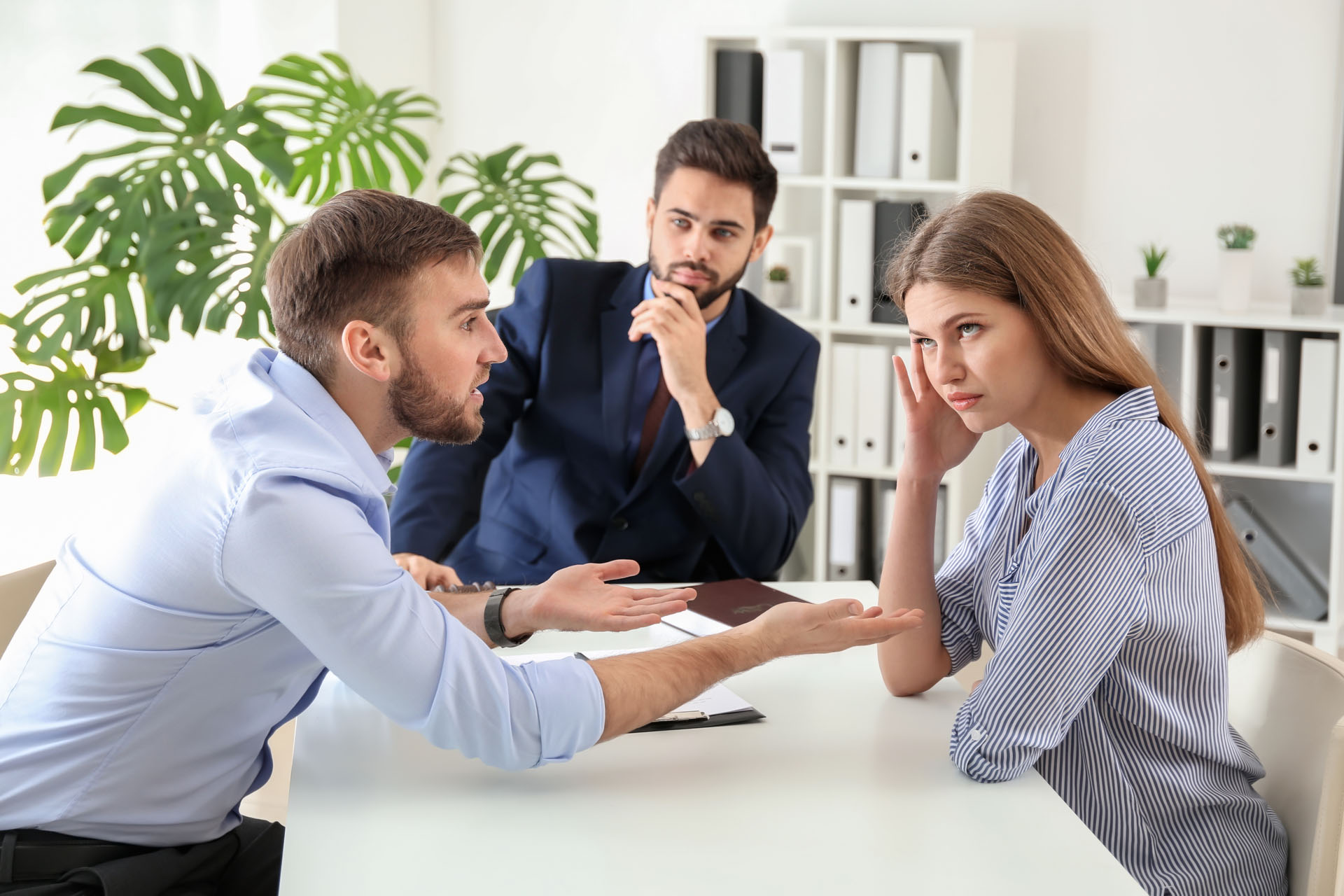 A couple sitting with a divorce mediator, arguing during a mediation session