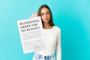 Woman holding a paper saying "Restraining order for no reason"