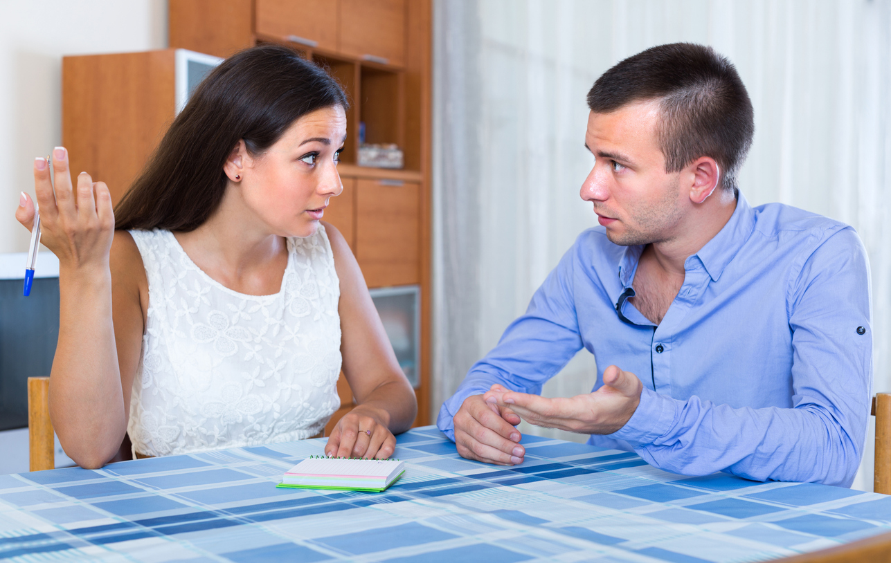 Sad young husband and wife discussing details of separation at home